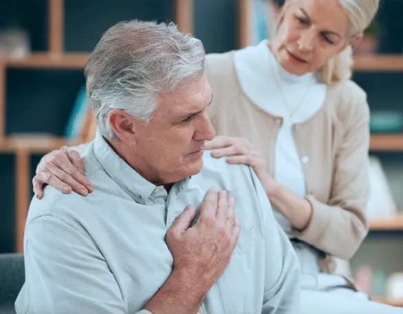 A woman helping a man with chest pain.