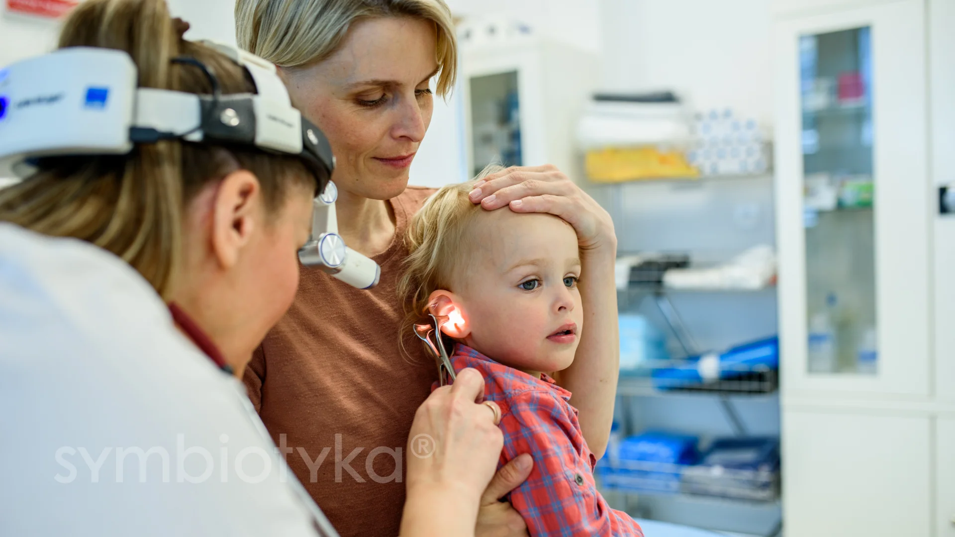 A little girl getting her hair cut by a woman.