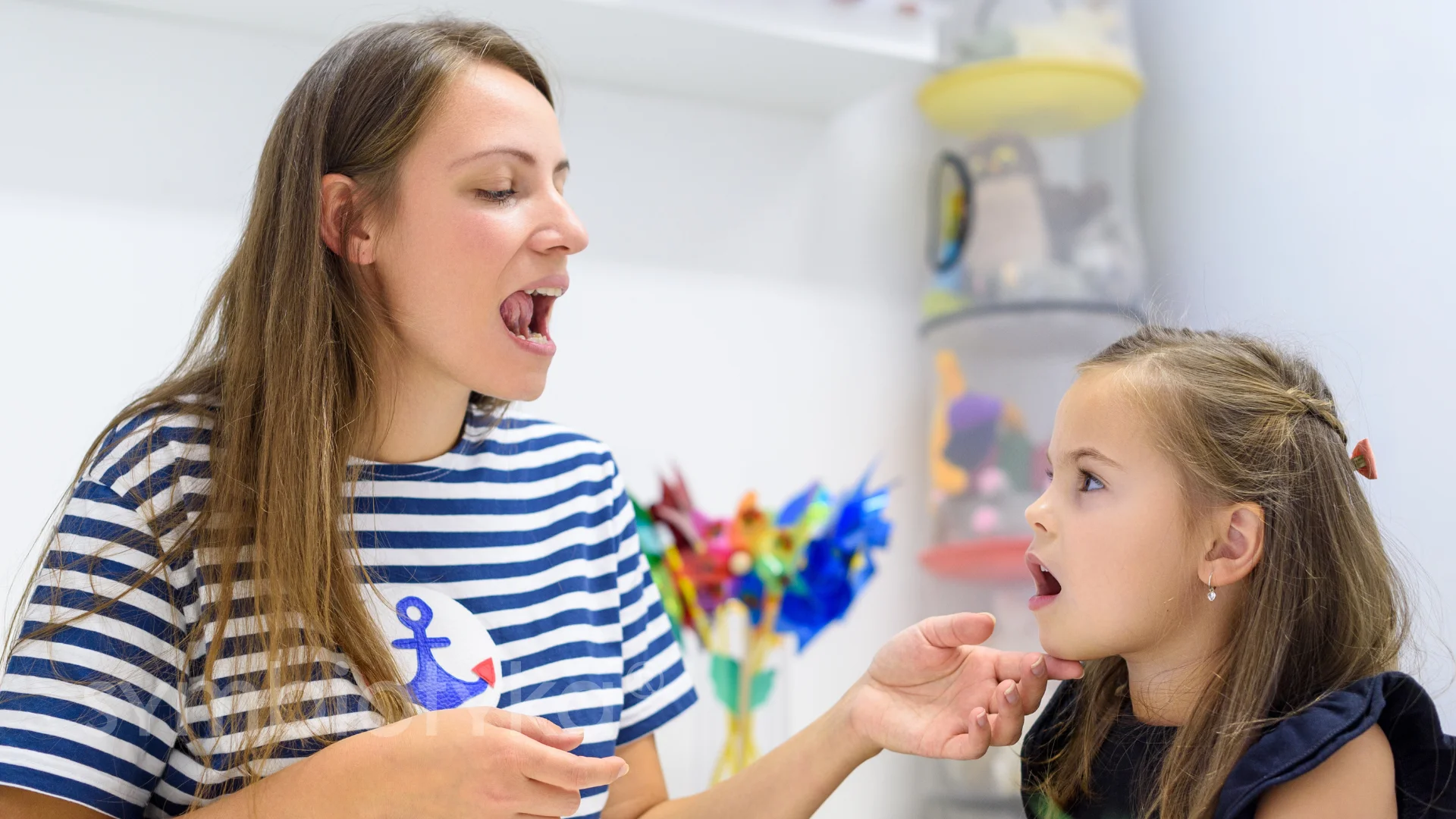 A woman and a little girl in a room.
