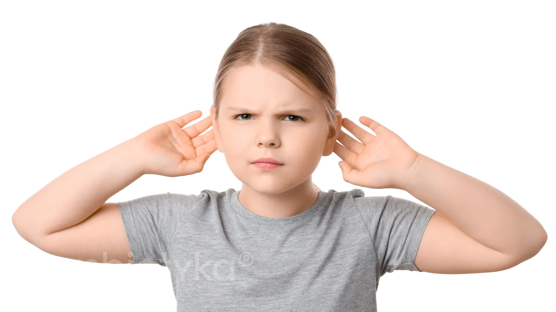 A young girl holding her hands to her ears.