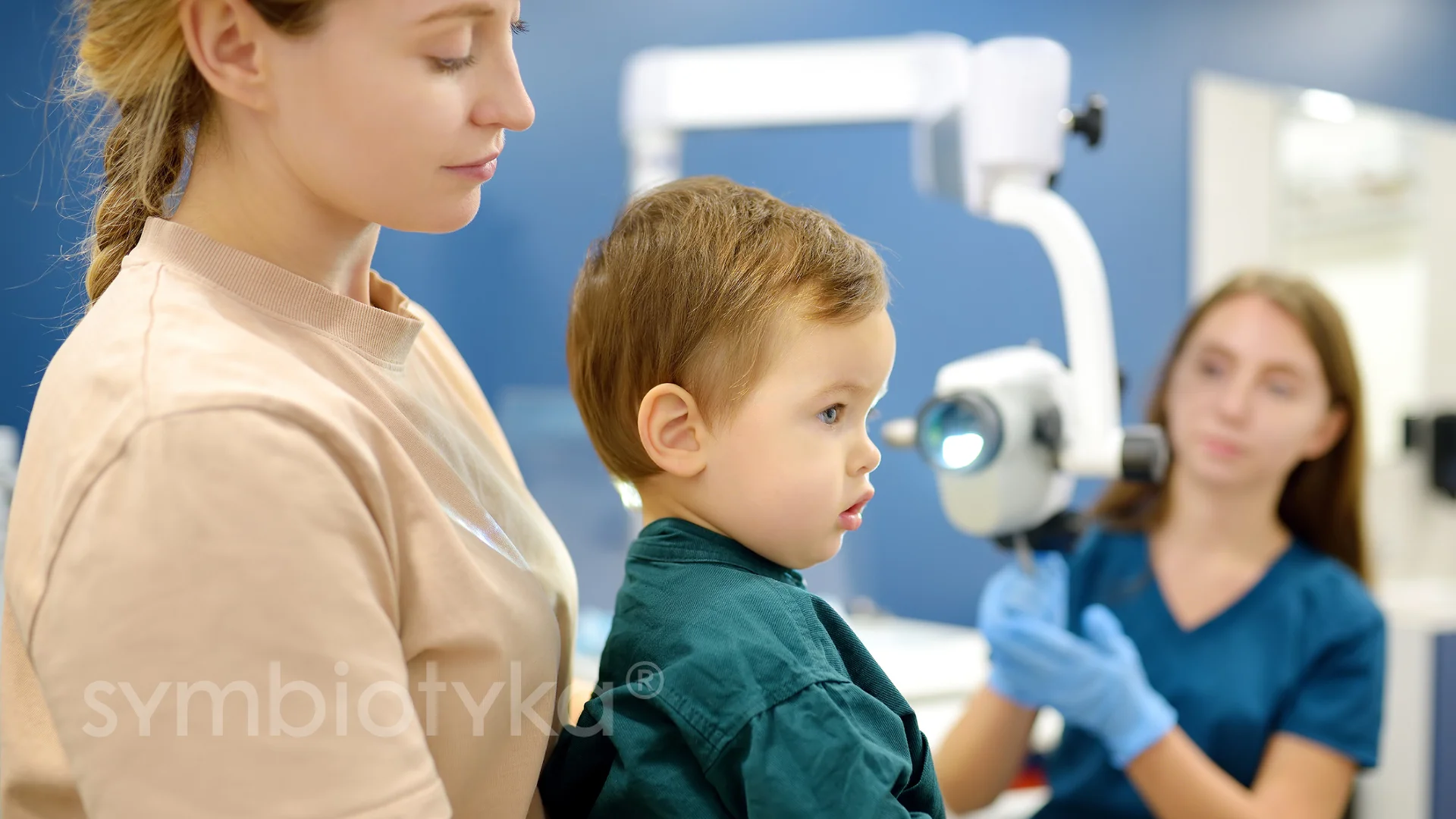 A young boy getting his teeth checked by a dentist.