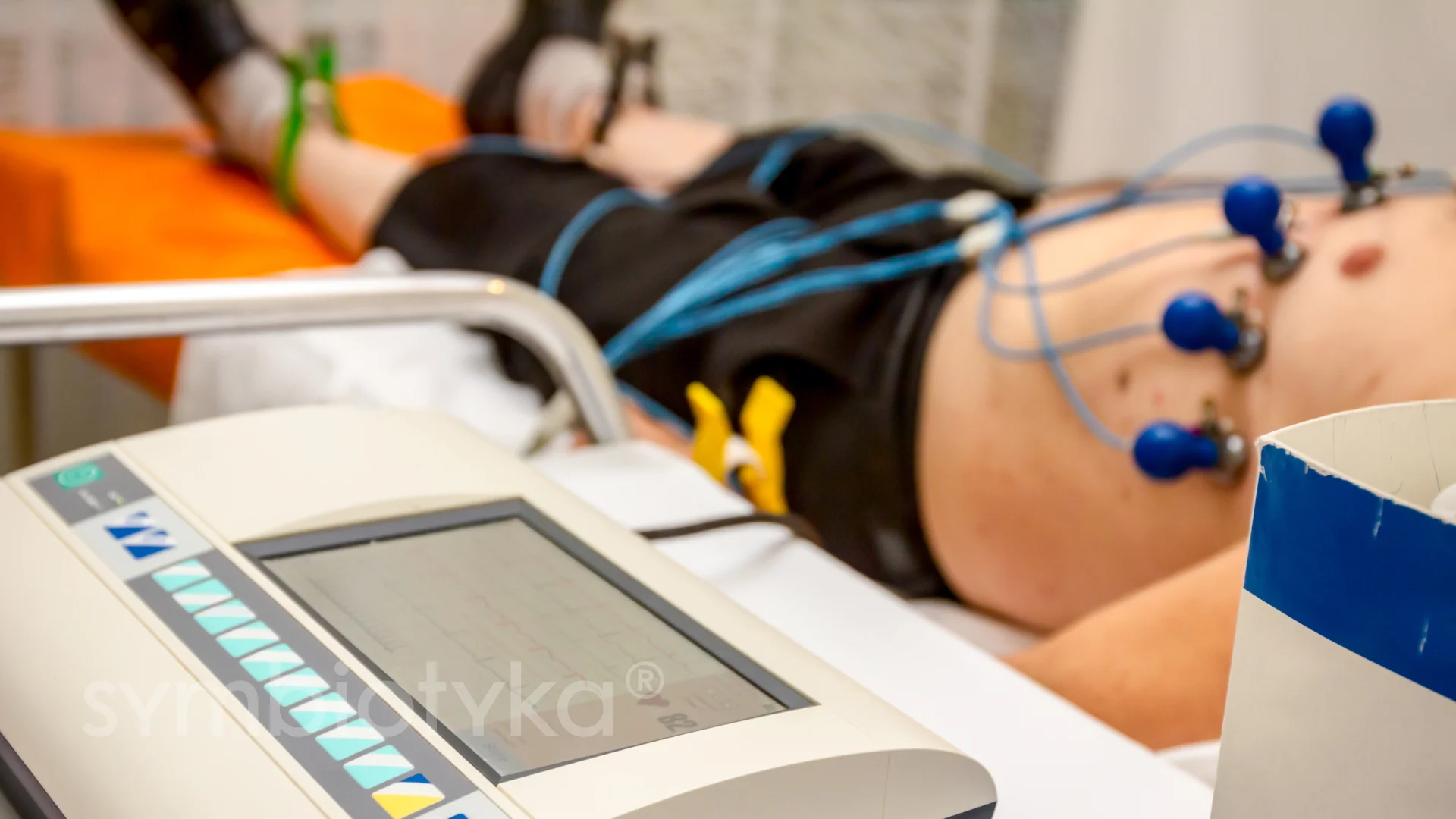 A person laying on a bed with a machine on it.