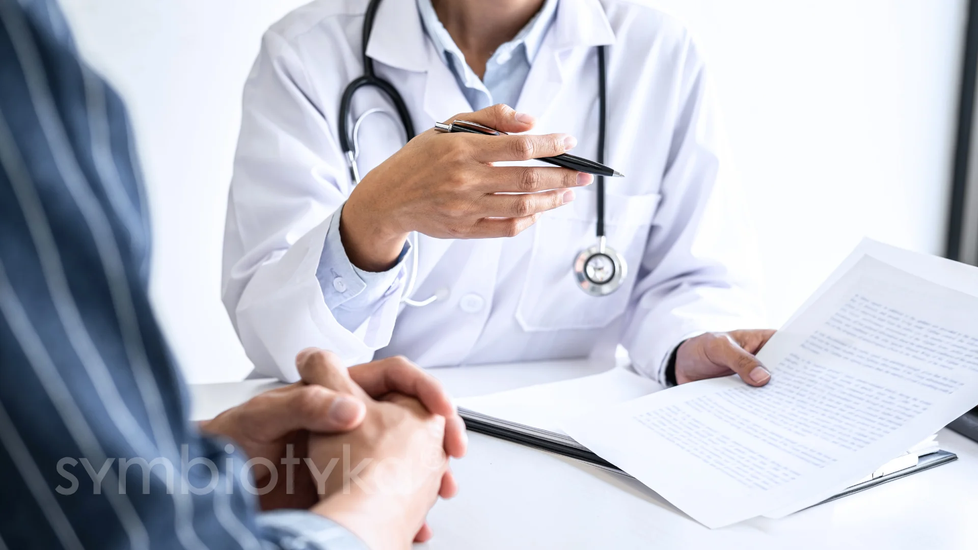 A doctor and a patient sitting at a table.