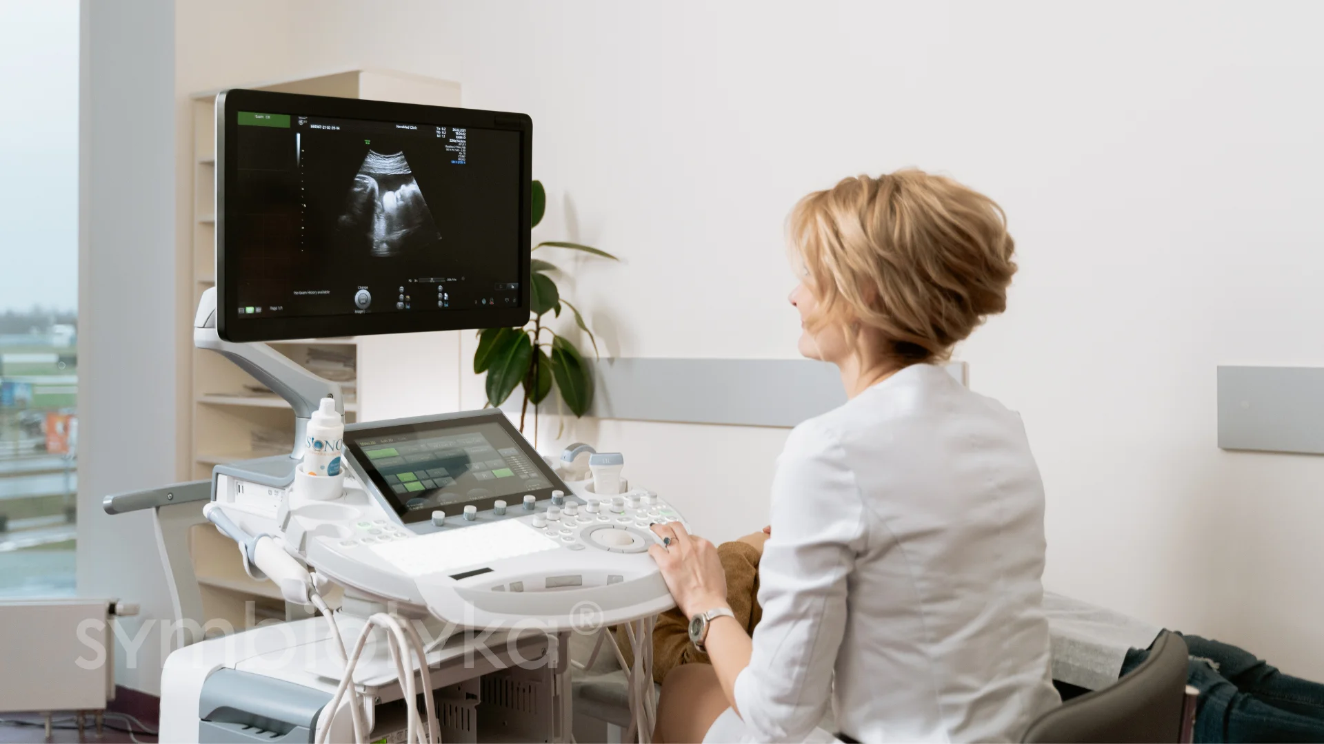 A woman sitting in a chair looking at an x - ray.