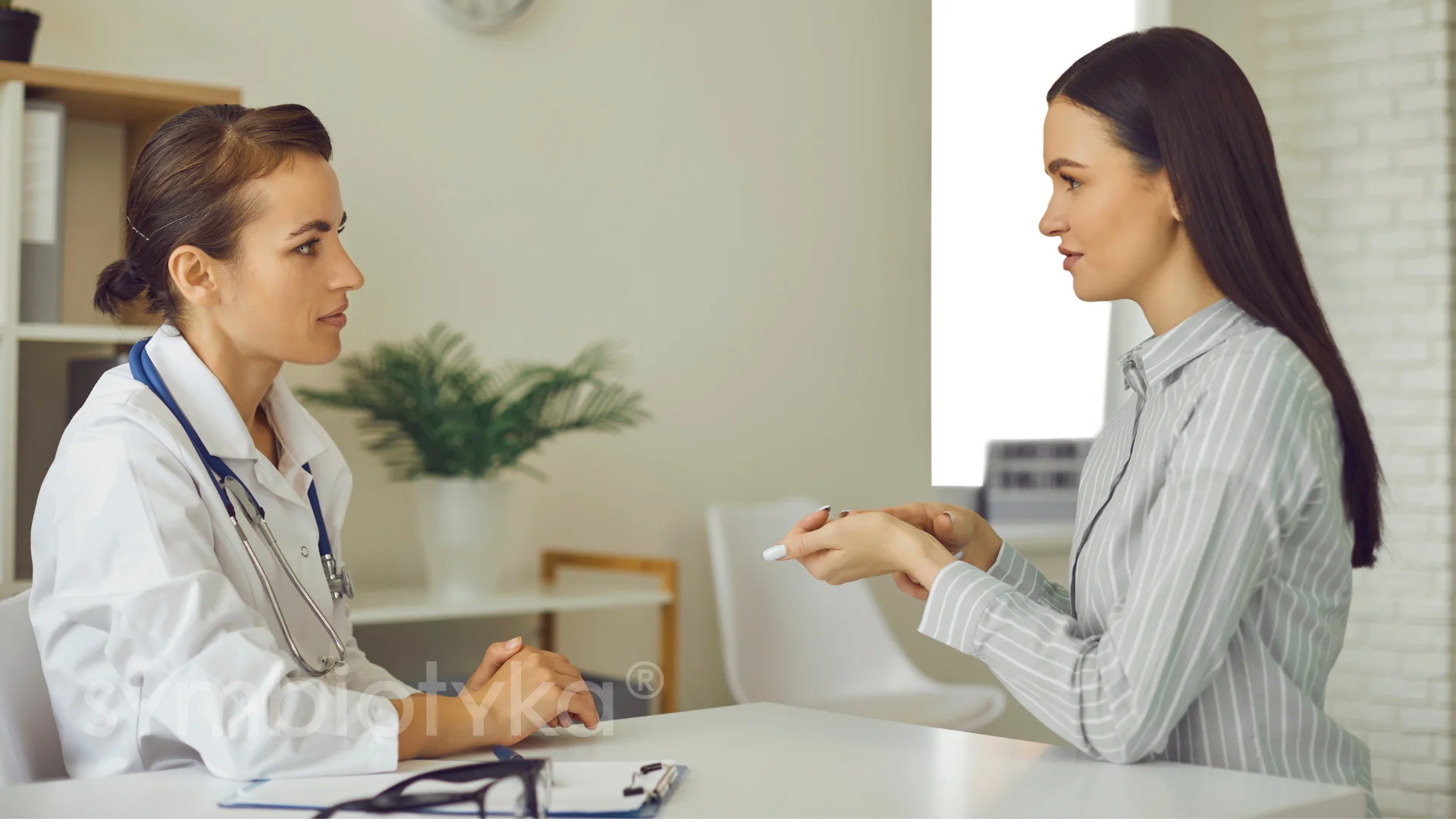 Two women sitting at a table talking to each other.