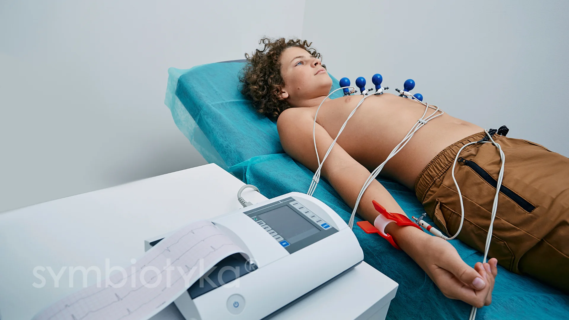 A man laying on a bed with a machine attached to his stomach.