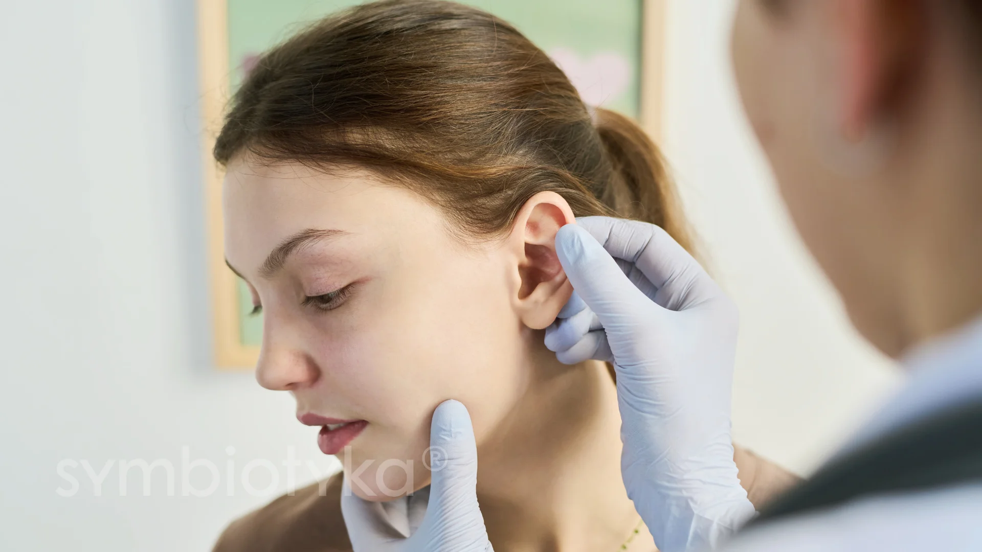 A woman getting her ear examined by a doctor.