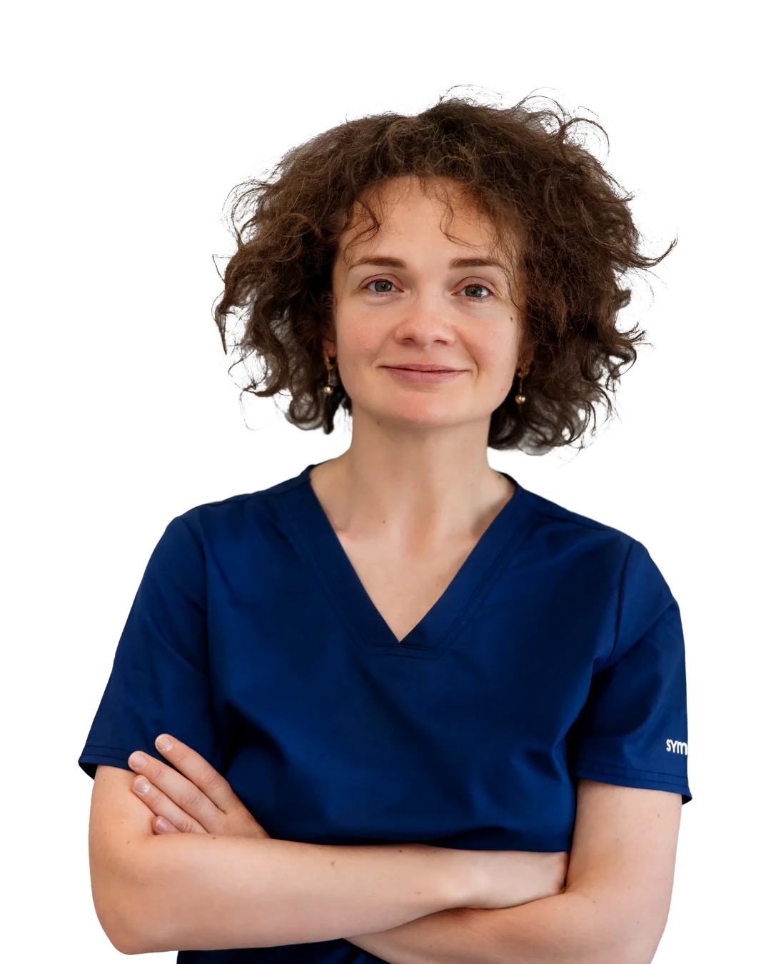 A woman in a blue scrub top with her arms crossed.