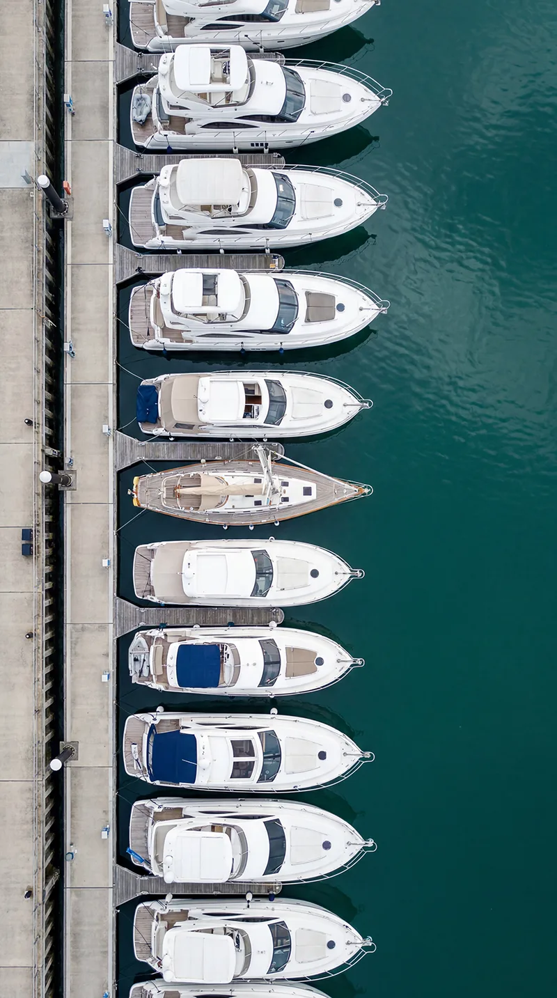 Aerial view of motor yachts moored stern-to along a marina dock