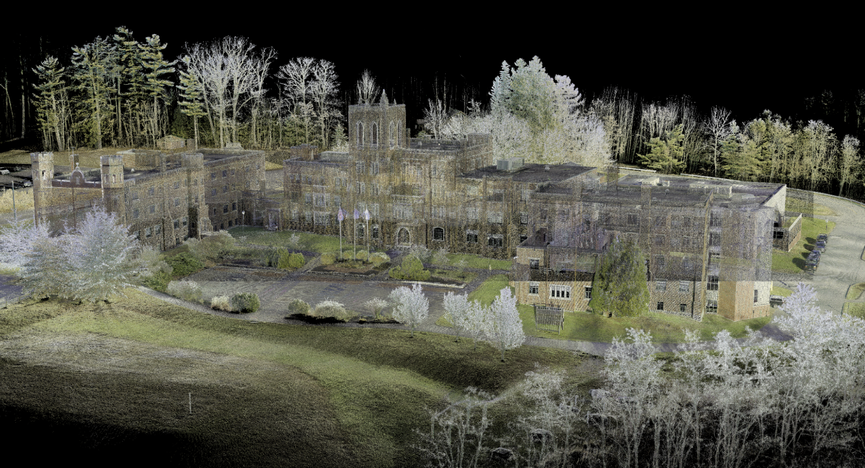 Aerial view of a large building nestled among lush green trees, showcasing the harmony between architecture and nature.