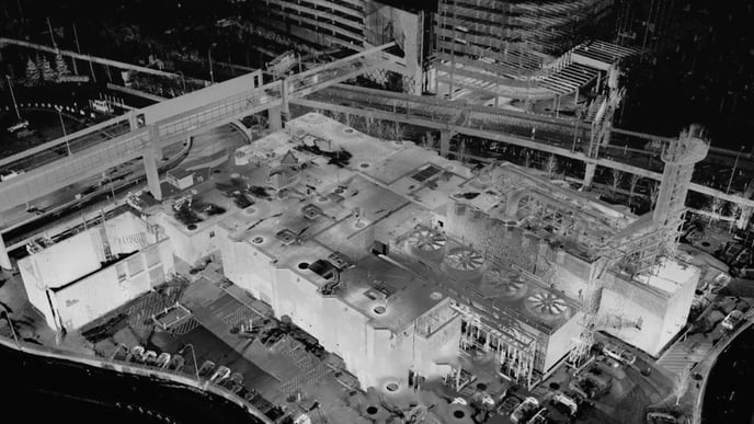 Aerial view of a bustling building surrounded by numerous people engaged in various activities..