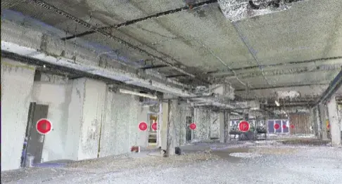 Interior of a building under construction with exposed ceilings, pipes, and ducts.