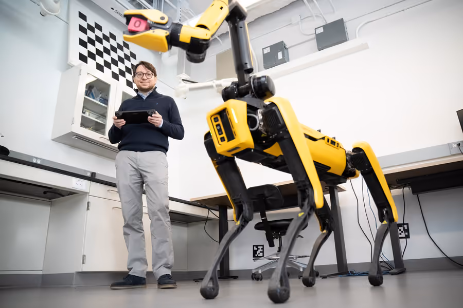 Man standing next to a 4-legged robot
