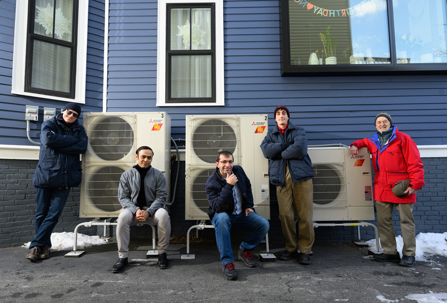 Five men standing outside, in front of home's AC units
