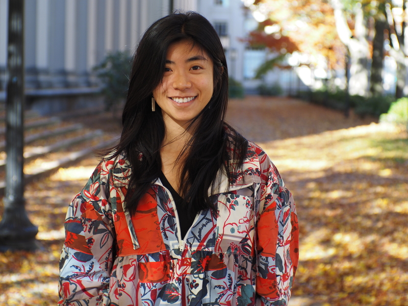 Portrait photo of Sarah Cen posing outdoors in a colorfully patterned jacket