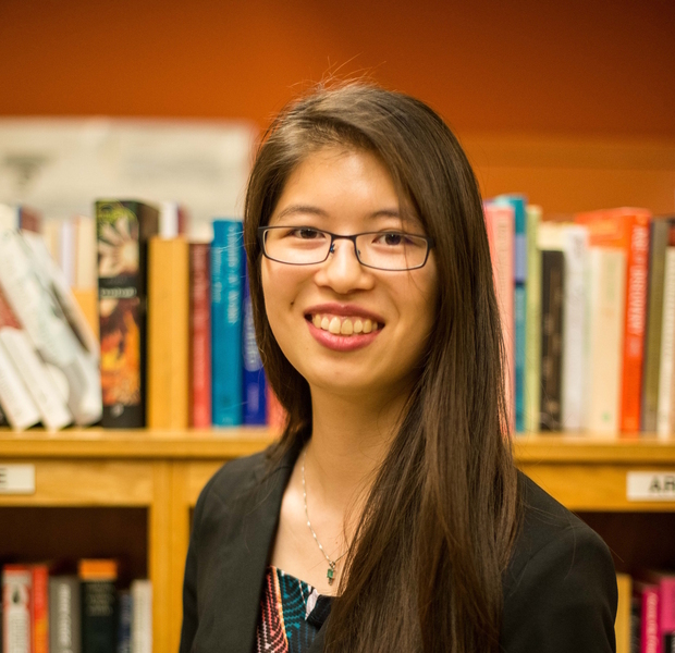 Headshot photo of Cathy Wu, who is standing in front of a bookcase.