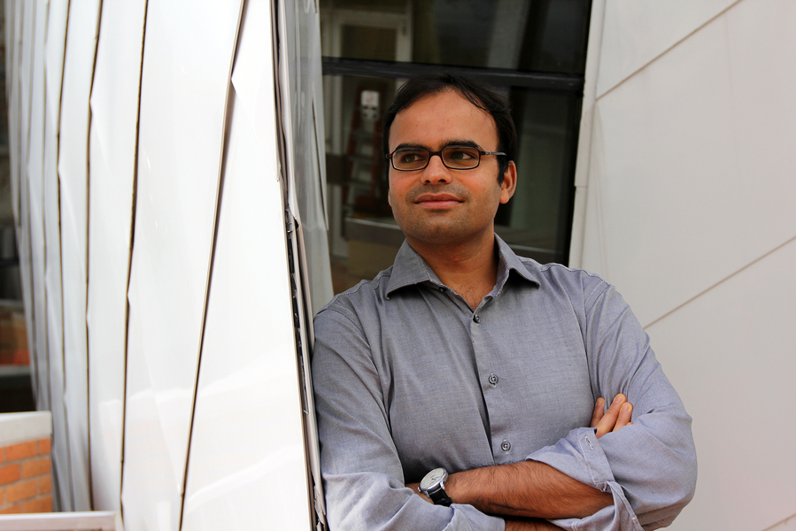 an image of Devavrat Shah leaning against a structure