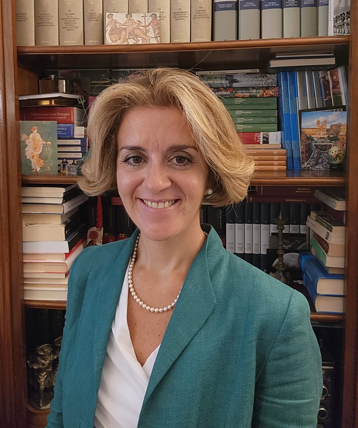a photo of Chiara Lo Prete standing infront of a bookshelf