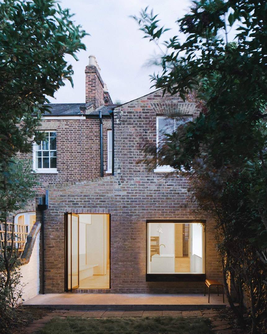 A serene living room with a large bay window, neutral furnishings, and a minimalist Scandinavian-style armchair.