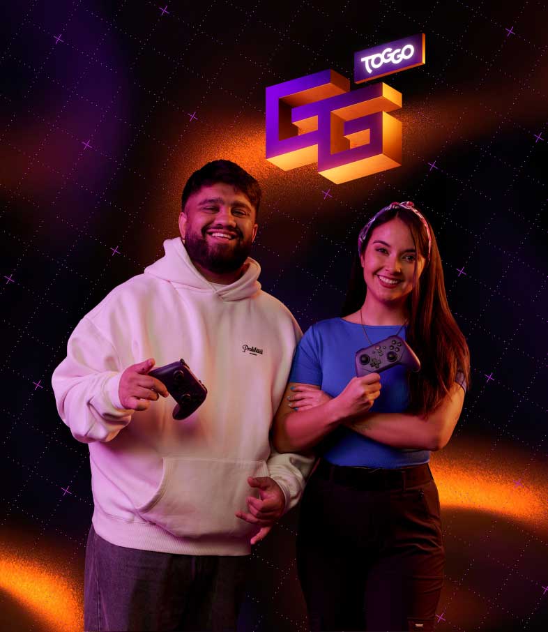 Zwei lächelnde Personen halten Gamecontroller neben einem leuchtenden VG TOGGO Logo vor dunklem Hintergrund.