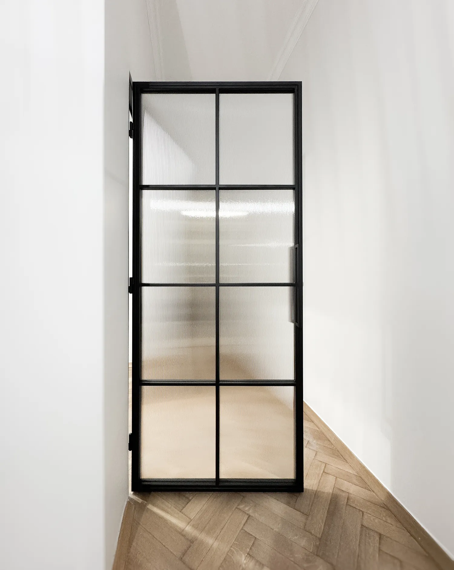 Op maat gemaakte enkelvleugelige stalen loftdeuren in zwart, industrieel design, voor de slaapkamer met een vulling van geslepen glas.