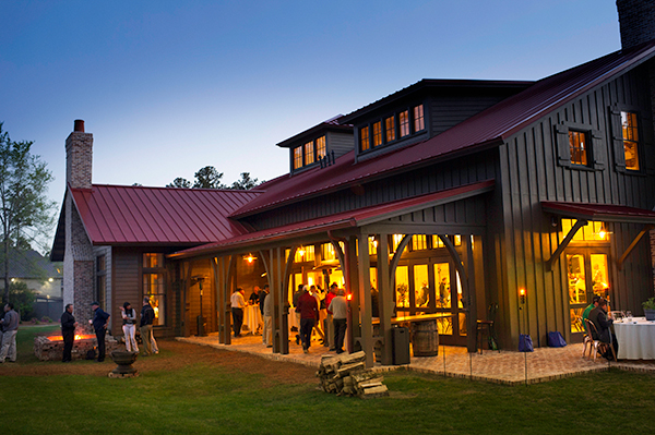 Outside of clubhouse at dusk with lights illuminating grounds around it