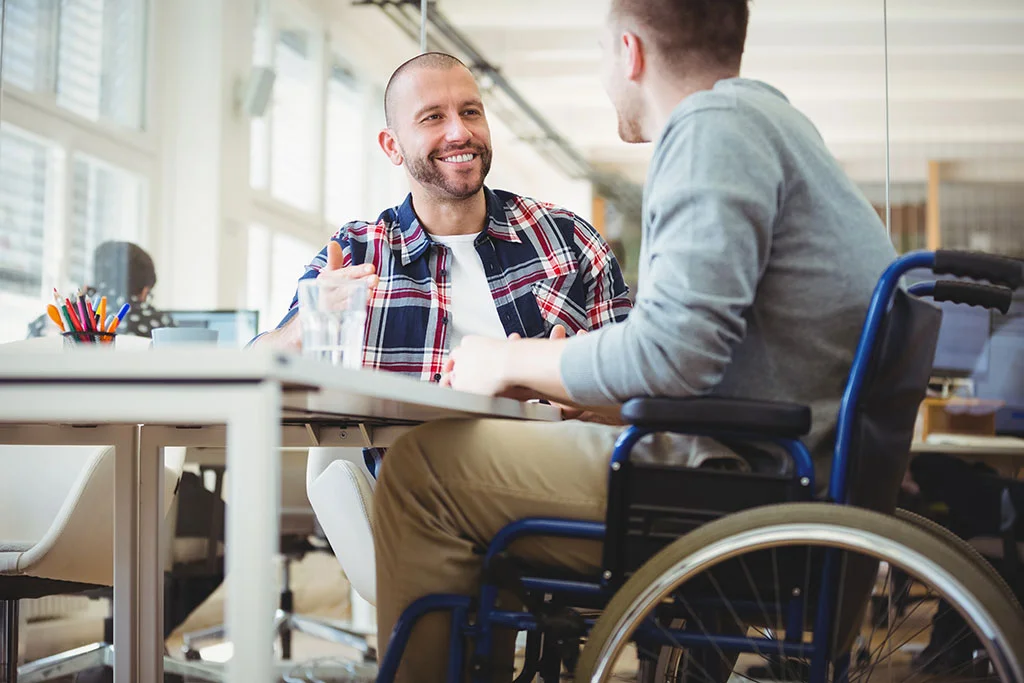 handicaphjælper med person i kørestol