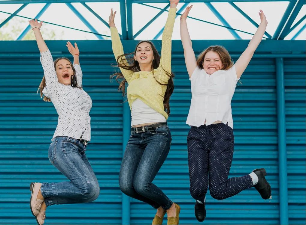 Three young people jumping for joy