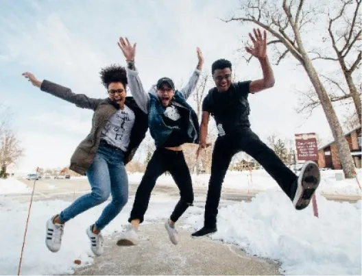 Three young people jumping for joy