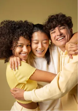 Three young people engaged in group hug
