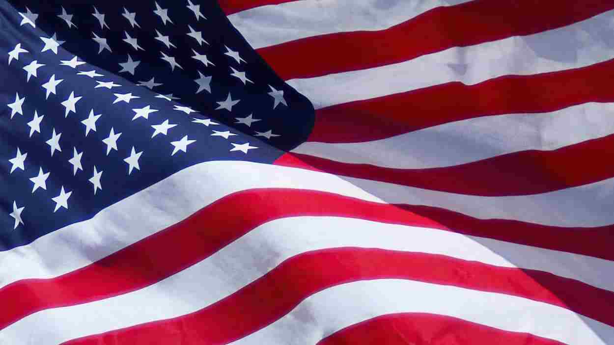 Close-up of the American flag waving, showing stars and red and white stripes.