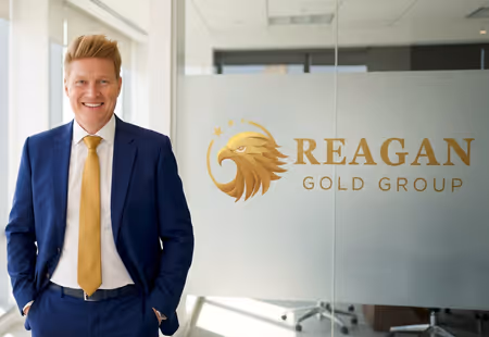 Alan standing near window with Reagan Gold Group logo