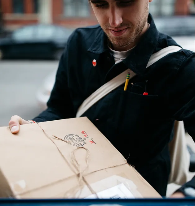 Courier handing over a parcel wrapped in brown paper and string