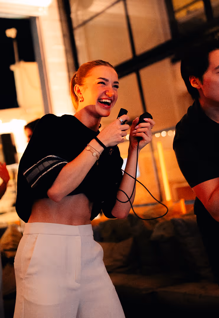 Attendee laughing while holding a microphone at the Midnite Release gaming event