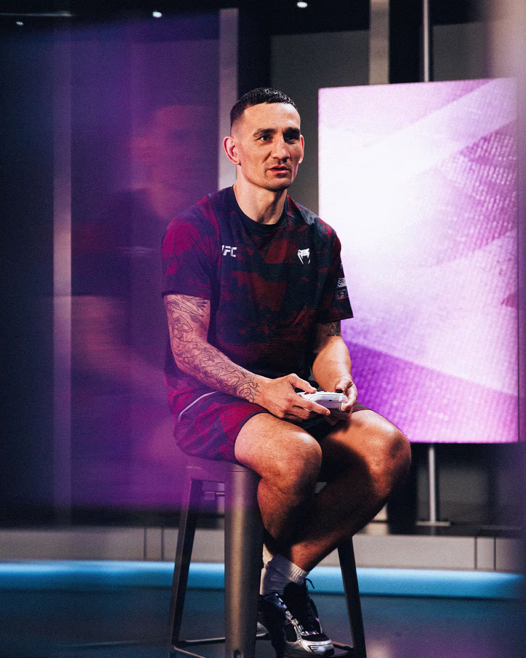 EA Sports UFC 6 campaign — fighter seated backstage playing a video game