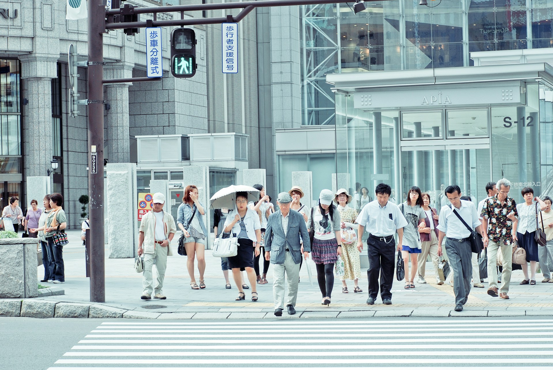 people crossing pedestrian lane near building at daytime - Photo by JJ Ying on Unsplash
