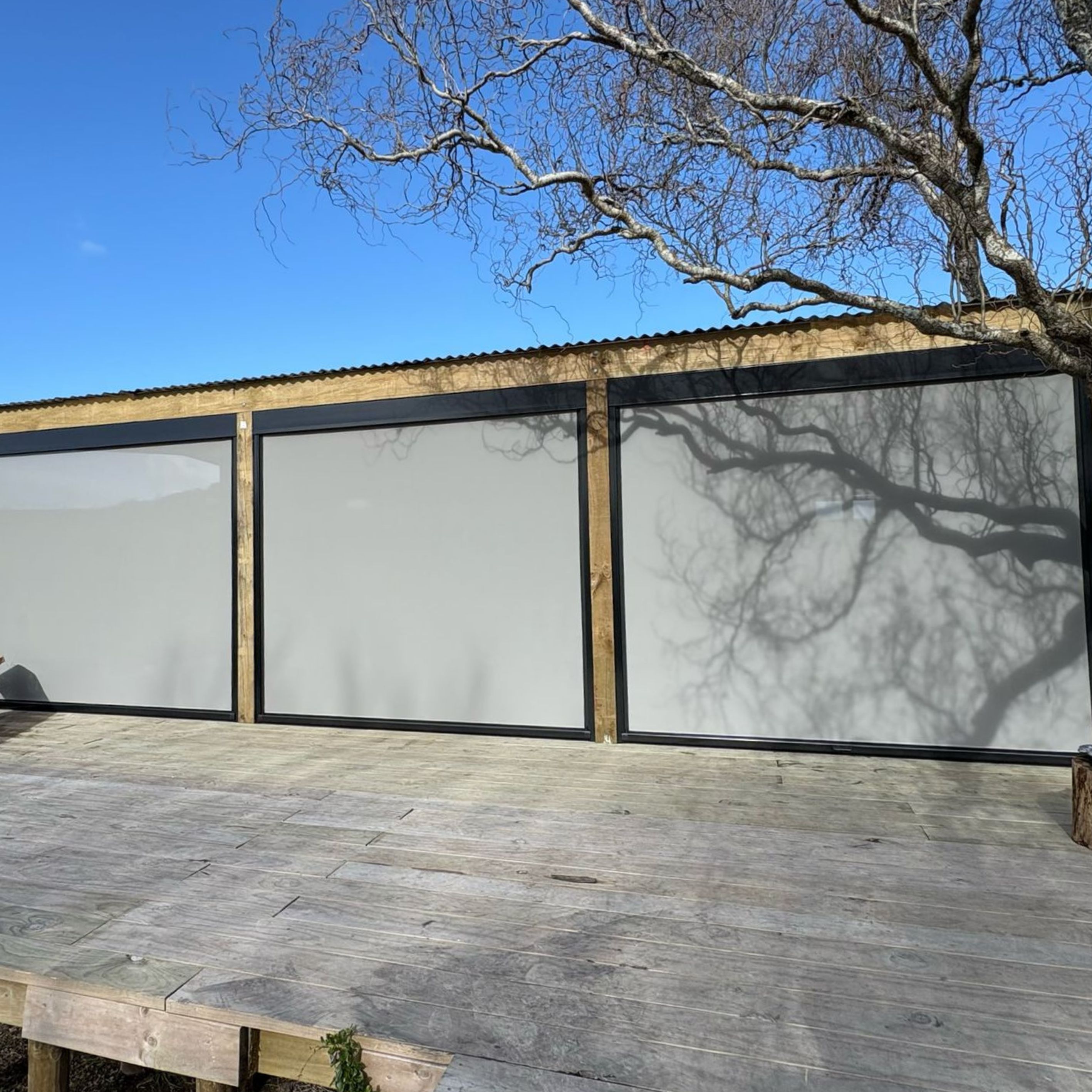 Ziptrak blinds extending a tiny home's living space in Parua Bay, by Shadeland