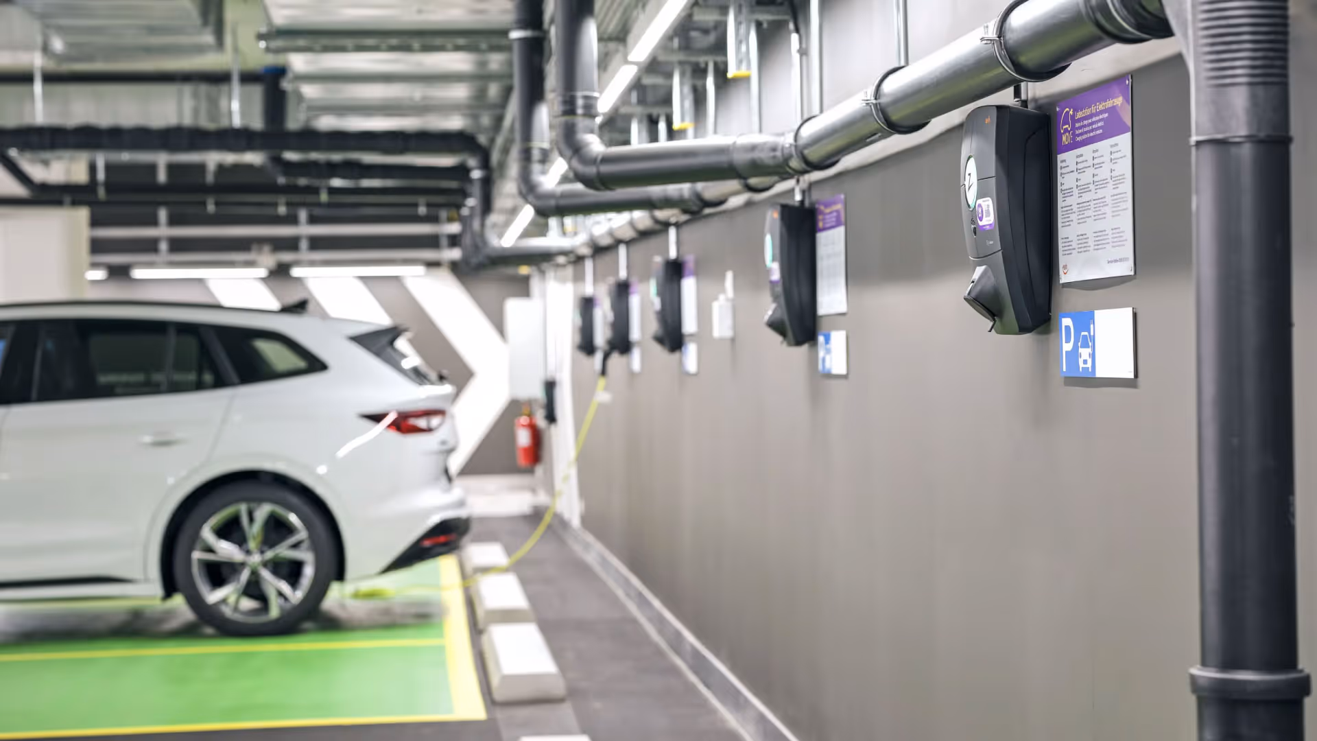 Ein Auto steht in einer Tiefgarage und wird von einer Wallbox aufgeladen.