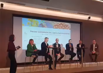 Table ronde avec six intervenants discutant sur scène, sous une présentation projetée intitulée "Penser autrement les approvisionnements