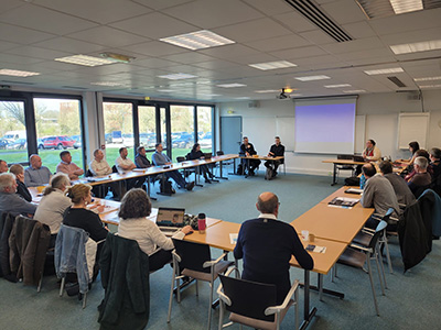 Réunion régionale de la Coopération Laitière avec des adhérents autour d'une grande table en U dans une salle lumineuse