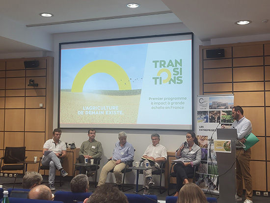 Table ronde sur les pratiques agricoles durables avec plusieurs intervenants face à un écran affichant « Transitions ».