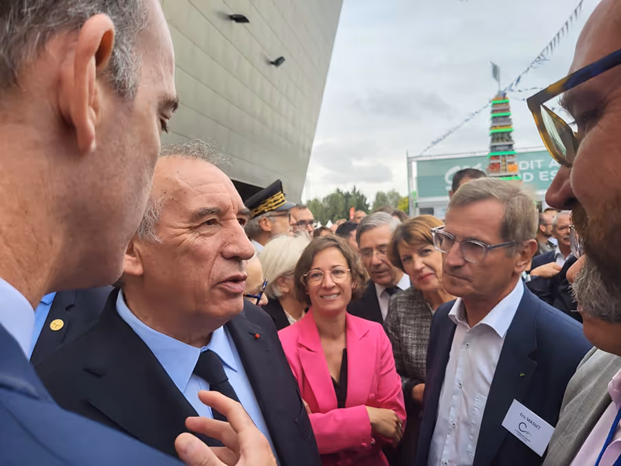 Échange entre élus et représentants d’organisations devant un bâtiment institutionnel, lors d’un événement officiel.