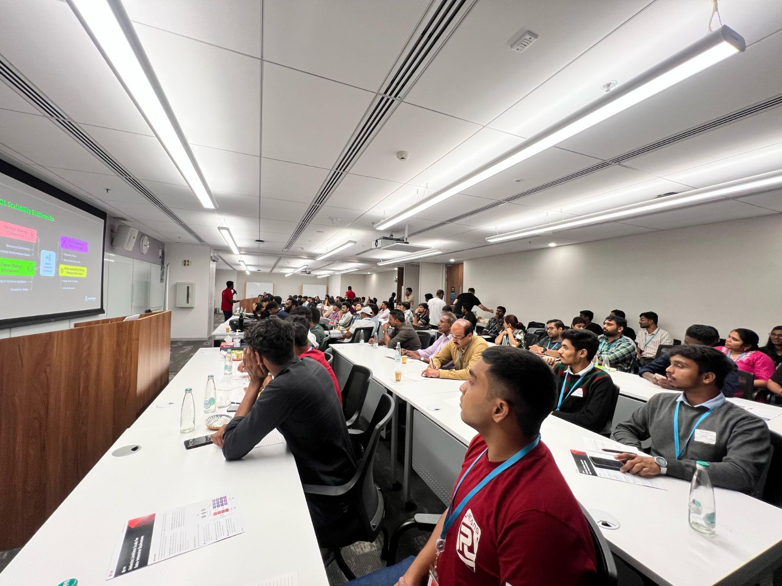An engaged audience of tech professionals listening in a classroom setting at the Mydbops-TiDB-AWS Distributed SQL meetup in Bengaluru.