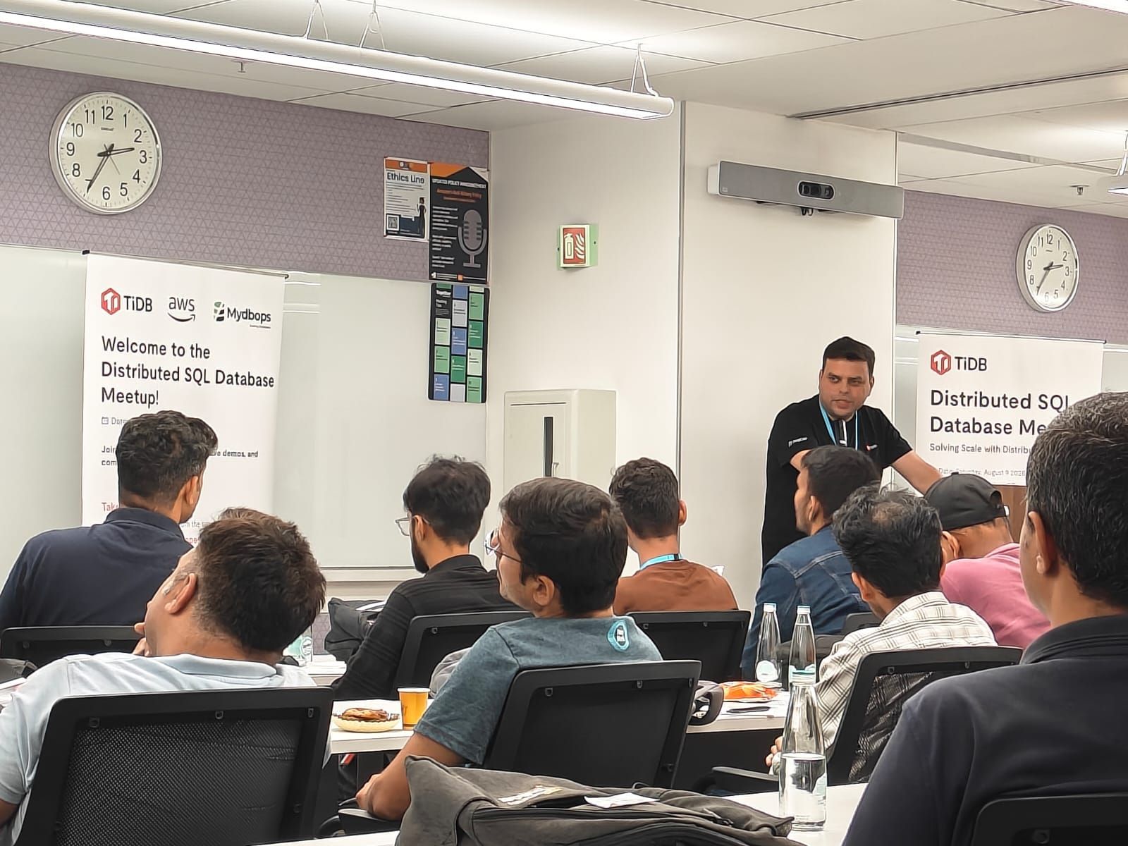Bhanu Jamwal from TiDB presenting on the main stage about database complexity and the "Frankenstack" problem at the Mydbops workshop.