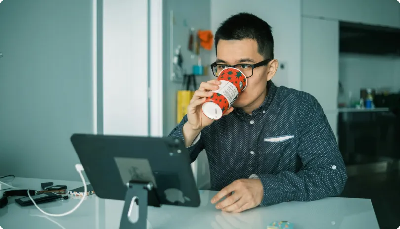 Man working at a laptop while drinking coffee