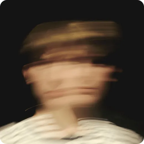 Image of a  blurred image of a man wearing a white shirt, creating an abstract and indistinct visual effect.