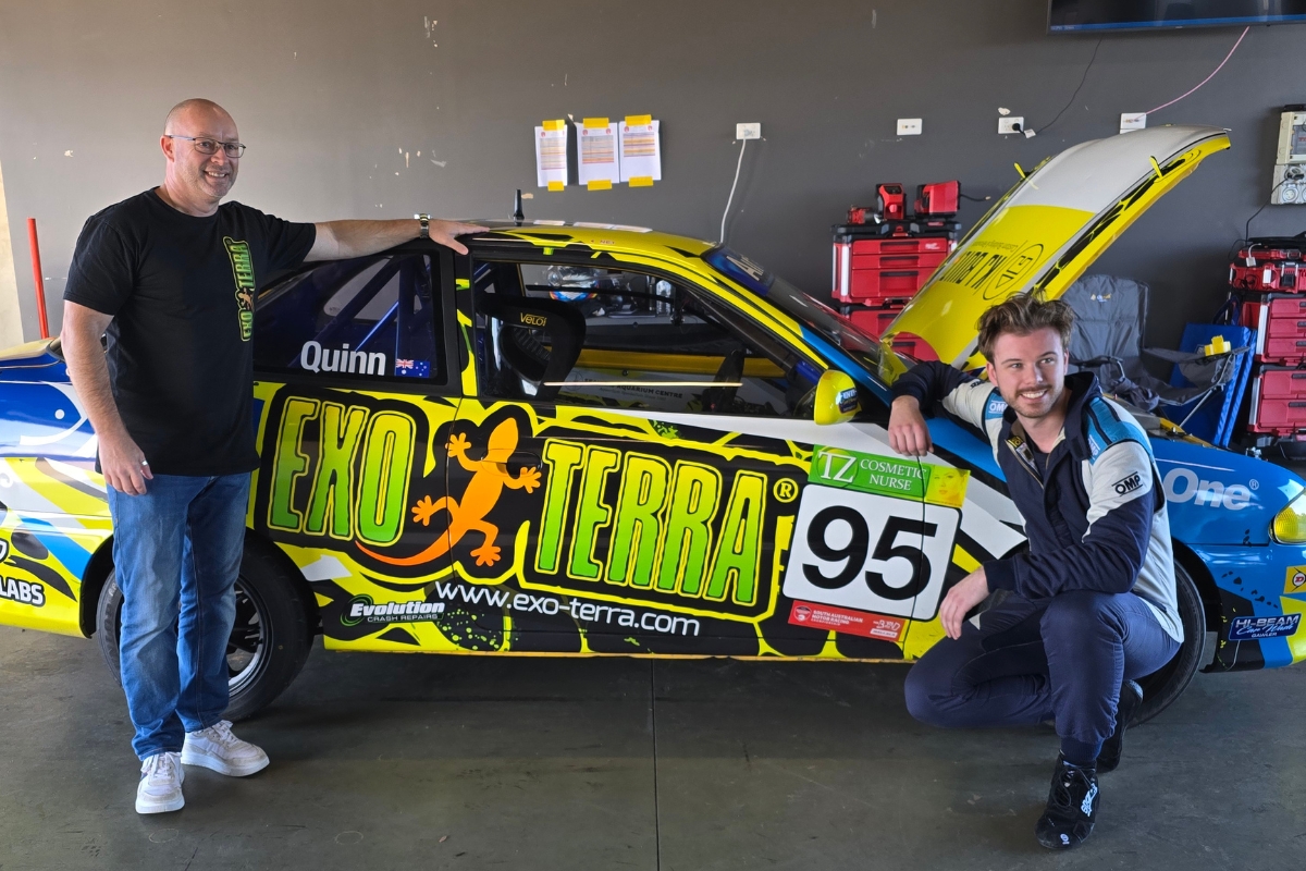 Team Sponsor and Driver Posing next to their logo on a race car