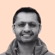 A man wearing glasses and a jacket.