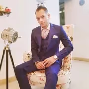 A man wearing glasses and a jacket.