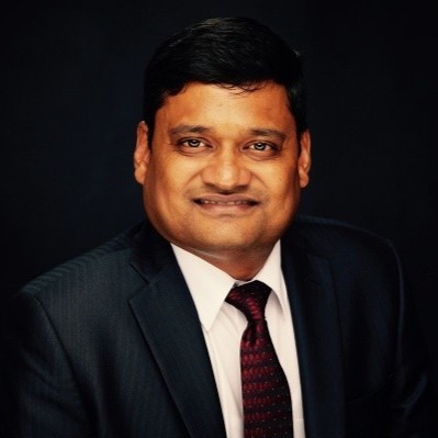 A man wearing glasses and a jacket.